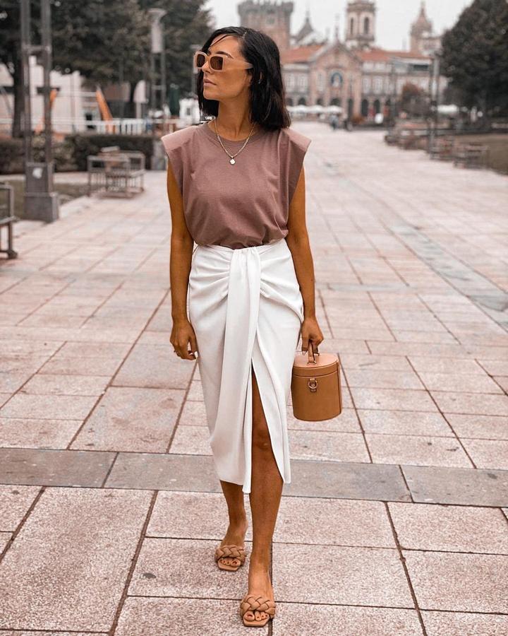 Filipa Rodrigues apostó y triunfó conjuntando la falda con otra de las prendas virales de la temporada: la camiseta con hombreras. Ella escogió el modelo de Zara en color tierra y añadió complementos a juego.