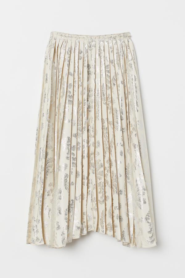 Confeccionada en tejido jacquard de poliéster reciclado con hilos brillantes en la trama, este modelo con pliegues en la parte superior viene con bajo asimétrico y cremallera oculta en un lateral. Es de H&M, cuesta 99 euros y está disponible únicamente en la talla 36.