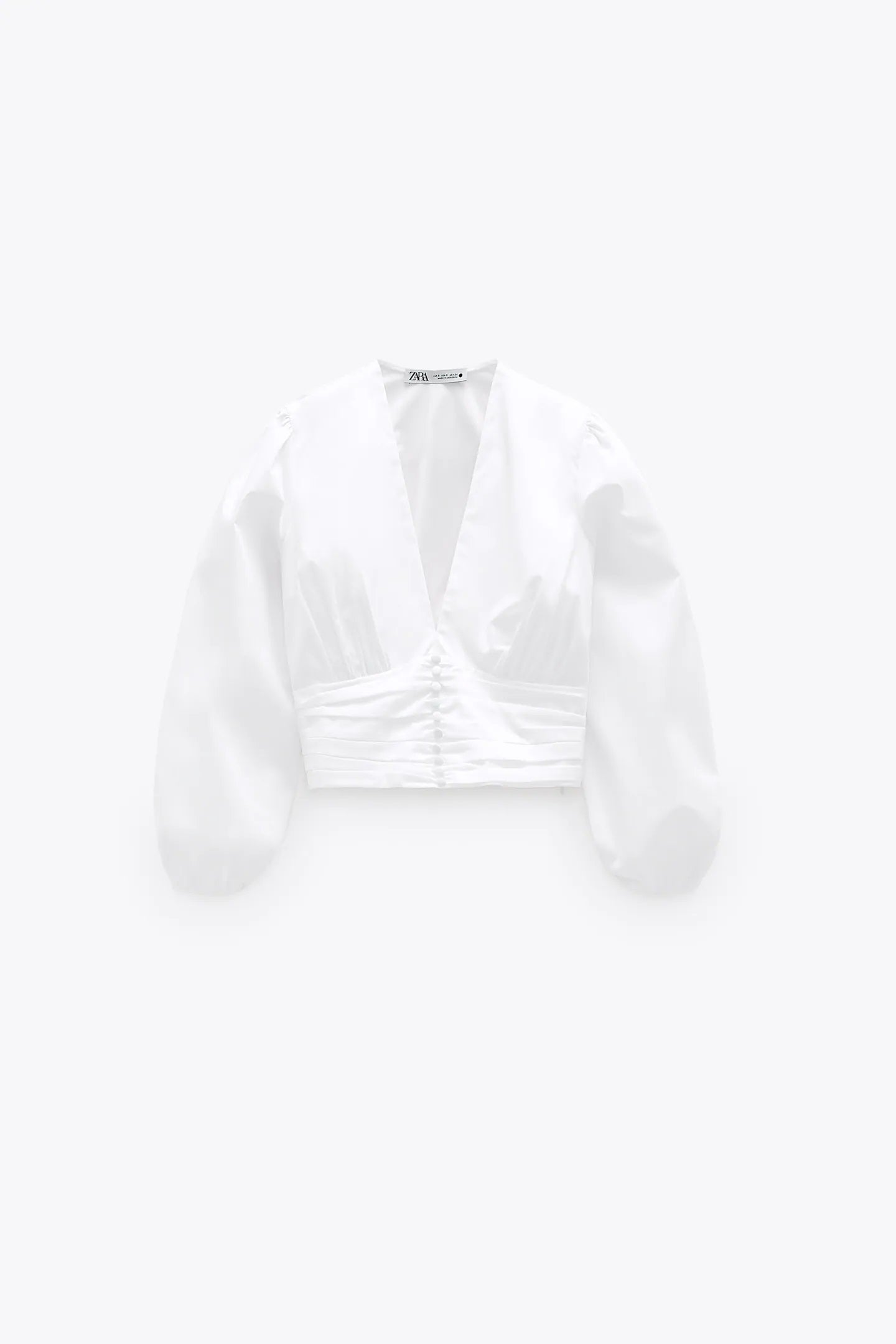 Blusa corta con bajo fajín, escote a pico y tejido popelín de los Special Prices de Zara. (15,99 euros).