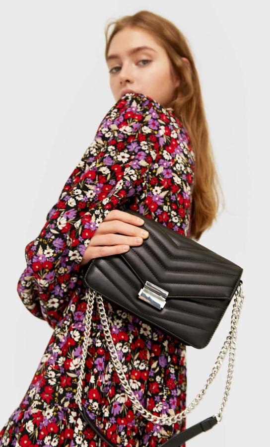 Asa de cadena metalizada y cierre en el mismo tono, esta bandolera de Stradivarius en color negro tiene el frontal acolchado y compartimento con cremallera trasero. Cuesta 17,99 euros.