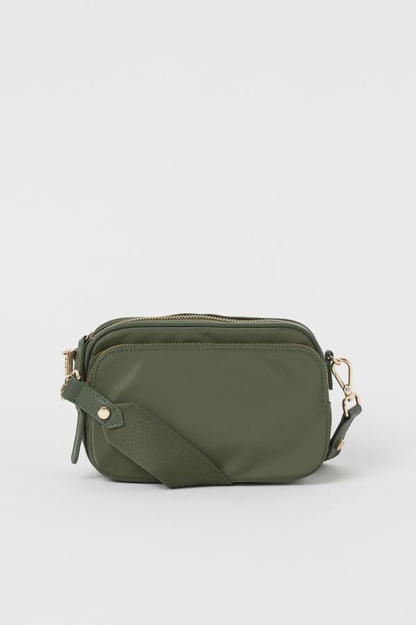Con exterior de poliamida y detalles de piel sintética, este bolso bandolera mini de H&M viene con dos compartimentos exteriores y asa de hombro extraíble. Tiene un precio de 17,99 euros y está disponible en caqui, negro y beige, pero el primer color solo se puede encontrar en la web de la firma.