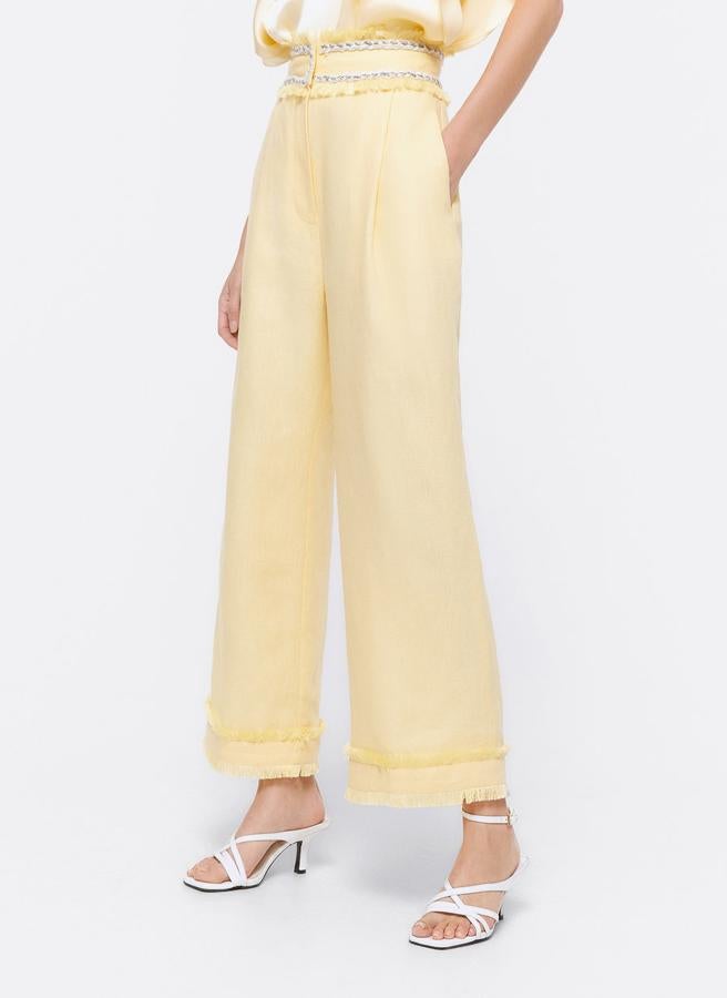 Pantalón ancho de lino en color amarillo con flecos en el bajo, de Uterqüe (62,30 euros).