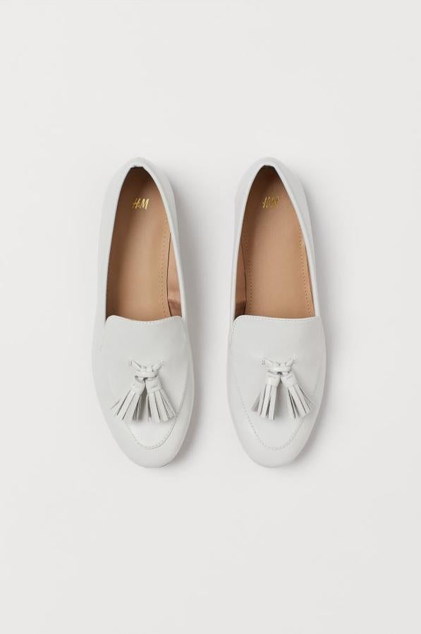 En color crema, con adorno de borlas en la parte delantera, estos mocasines de H&M tienen un precio de 19,99 euros y están disponibles en los números 41 y 42.