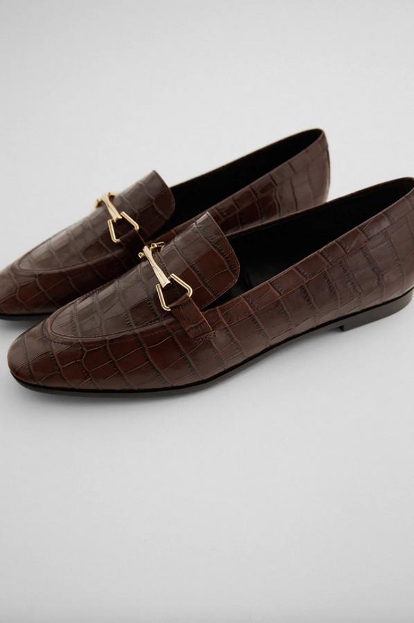 En color marrón con estampado animal en el corte, estos mocasines de Zara vienen con detalle de hebilla dorada en el empeine. Cuestan 45,95 euros y están disponibles entre los números 35 y 42.