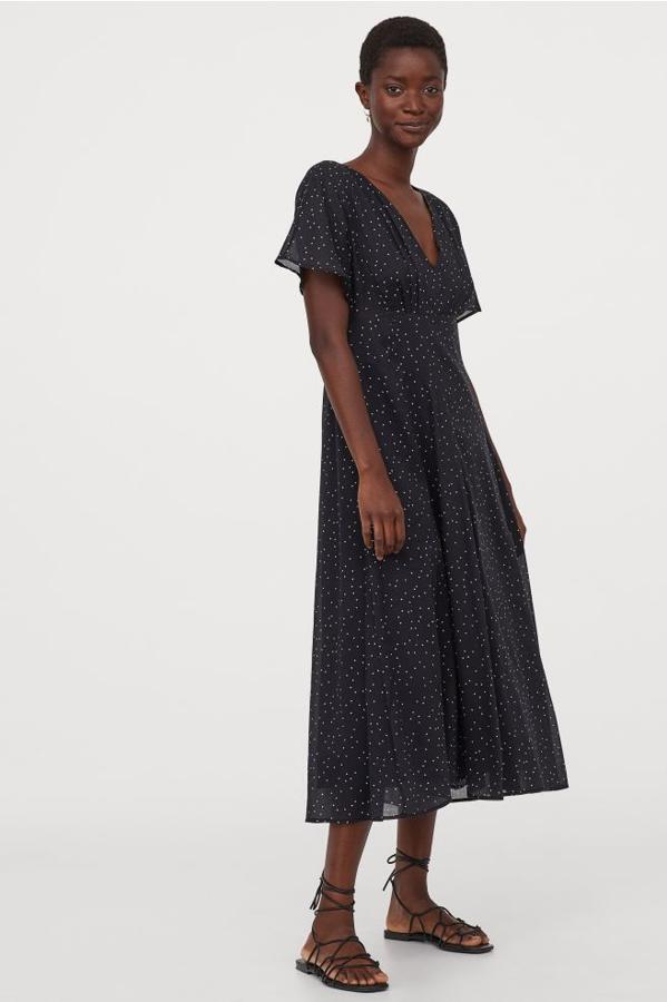 En H&M hemos encontrado este vestido midi en mezcla de modal y algodón de fondo negro con lunares mini en color blanco. Con mangas cortas, escote de pico y falda asimétrica, tiene un precio de 49,99 euros y solo podemos comprarlo en la web de la firma entre las tallas 32 y 46.