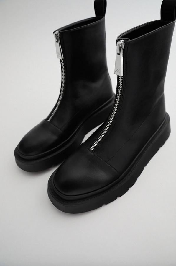 Con cierre de cremallera en la parte delantera y tirador en la trasera, estos botines planos en color negro de Zara con suela gruesa tienen un precio de 35,95 euros y están disponibles entre los números 35 y 42.