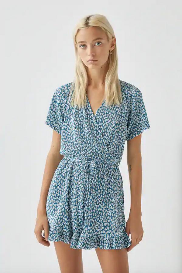 Tejido plisado con estampado de flores blancas sobre fondo azul para este mono corto de Pull&Bear con cuello redondo, mangas cortas y perneras anchas. Cuesta 19,99 euros y está disponible entre las tallas XS y XL.