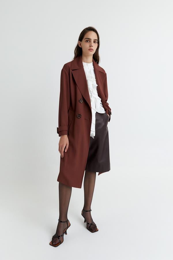 En color marrón, con cierre de botones a contraste y cinturón a tono, esta gabardina fluida de Sfera con manga raglán cuesta 69,99 euros y está disponible en las tallas S y M.