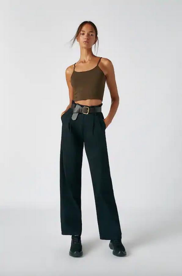 En color negro o en camel medio, estos pantalones de Pull&Bear con diseño flare y tiro alto vienen con cinturón añadido y perneras rectas. Cuesta 29,99 euros y está disponible entre las tallas XS y XL.