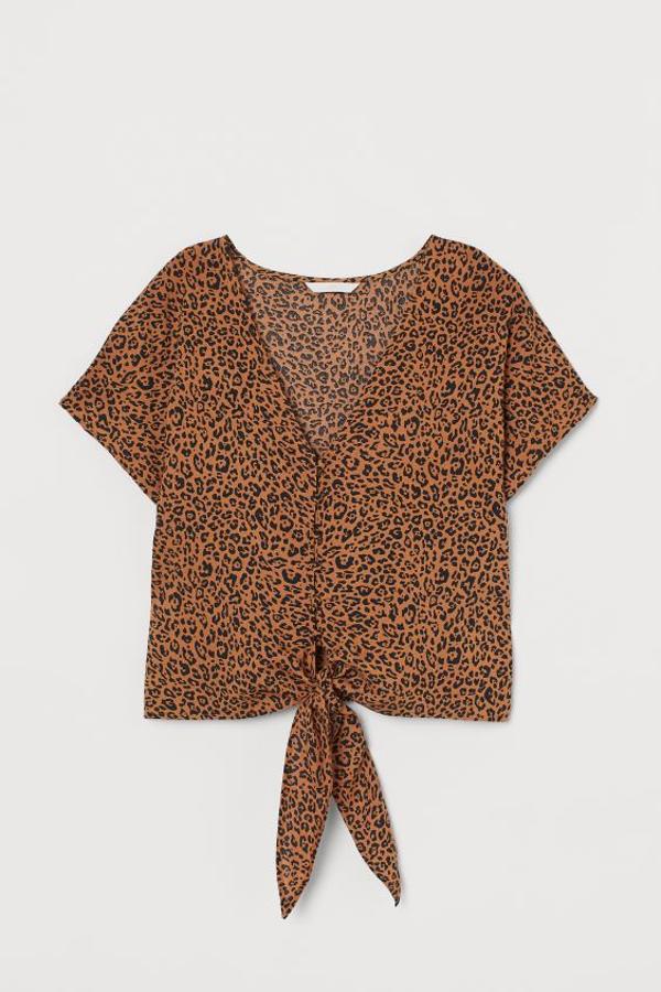 Tejido vaporoso y botones revestidos a tono para esta blusa de H&M con escote de pico, mangas dolman cortas y lazada en el bajo. Tiene un precio de 19,99 euros y está disponible en las tallas 32 y 34.