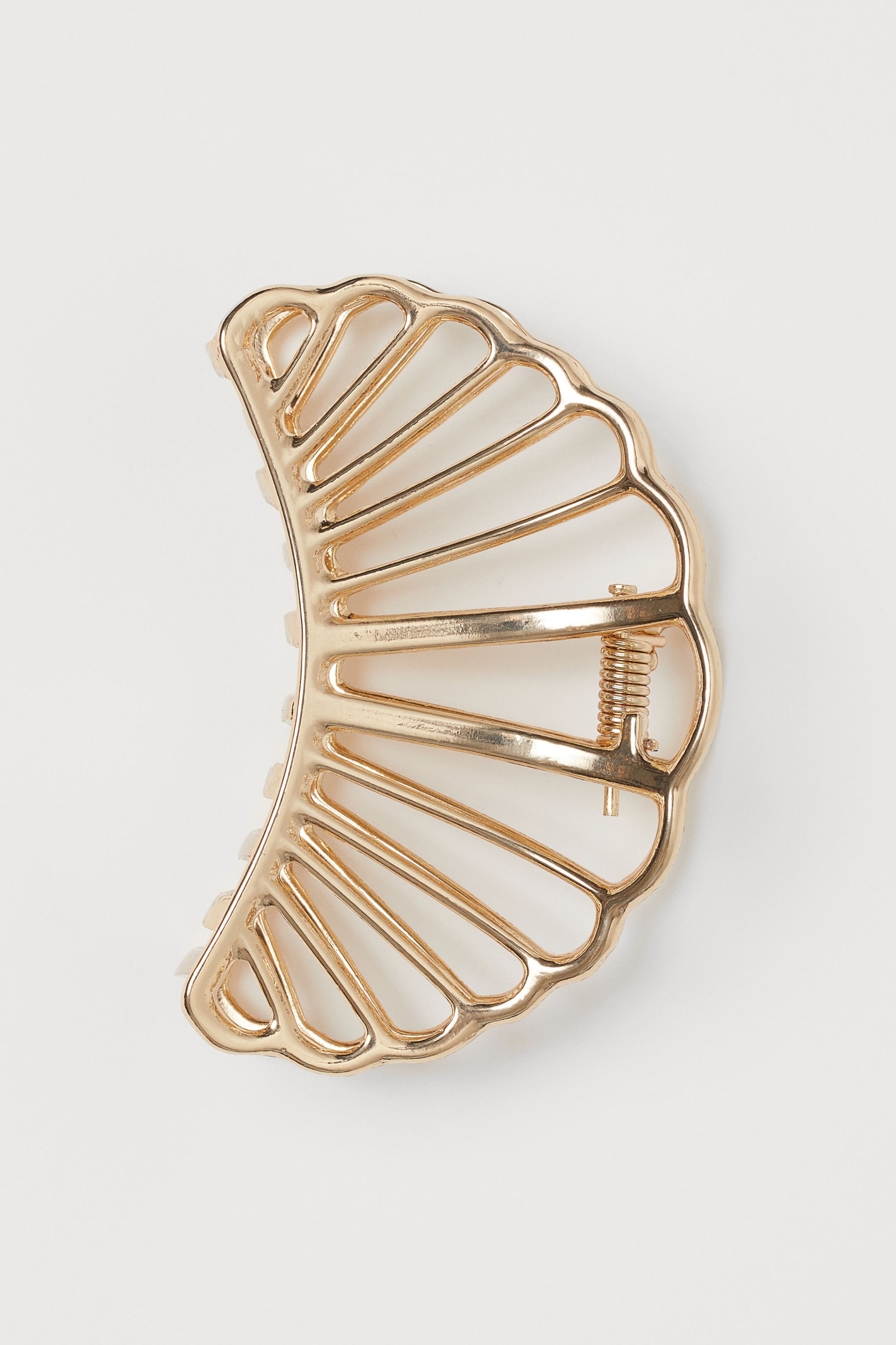 El accesorio para el pelo más cómodo: la pinza noventera. Ficha este diseño cut out de H&M en mental dorado. (6,99 euros).