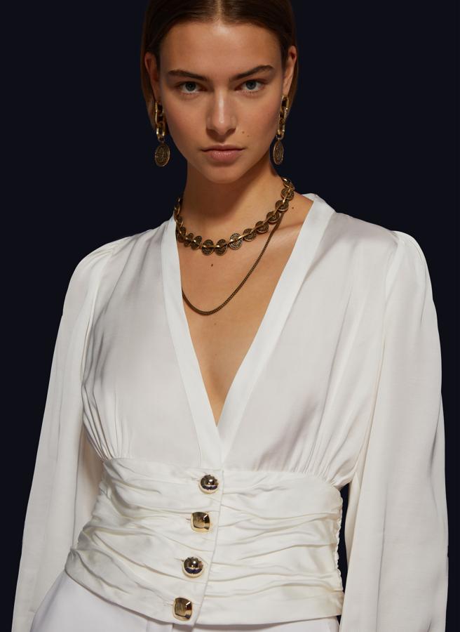 Y hablando de camisas blancas, esta de Uterqüe (79.90 euros) es perfecta: su color nos ayuda a prolongar el efecto de nuestro bronceado casi tanto como su favorecedor escote en uve.