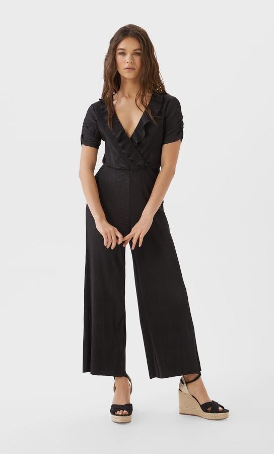 Diseño plisado con volantes en el escote de pico para este mono negro de Stradivarius con detalle de frunce en el lateral y cintura engomada. Cuesta 19,99 euros y está disponible en las tallas S, M y L.