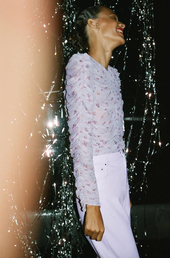 El lila no podía faltar en esta selección festiva y llega de la mano de esta blusa semitransparente de cuello redondo y manga larga con detalle de tejido fruncido en el frontal y las mangas. Cuesta 29,95 euros y está disponible entre las tallas XS y XXL.