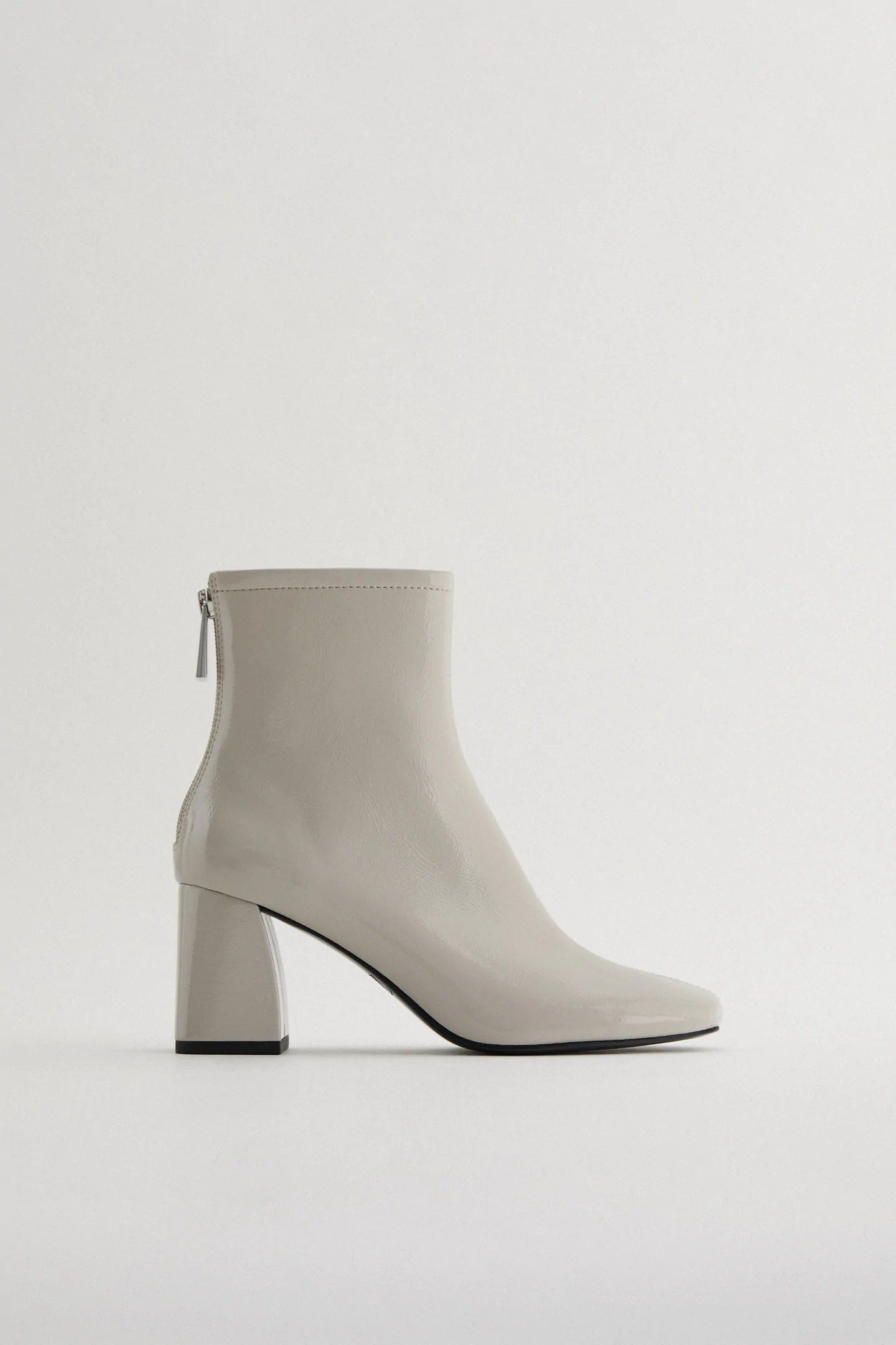 Botines blancos de tacón ancho y punta cuadrada efecto charol de Zara. (29,95 euros).