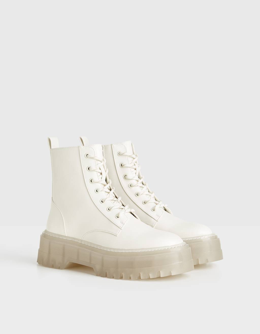 Otra versión de las botas blancas: acordonadas, de efecto piel y con plataforma traslúcida. 39,99 euros en Bershka.