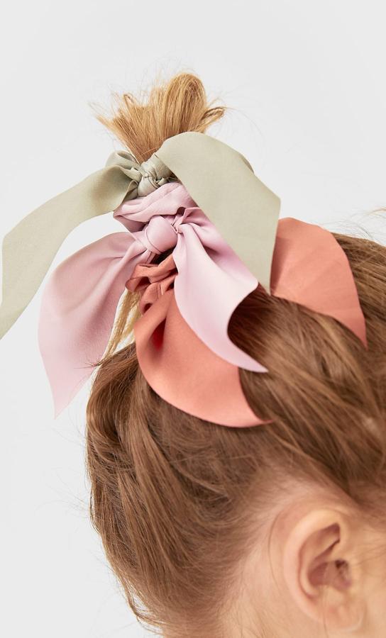 La tendencia noventera de los coleteros sigue en auge este otoño. Busca unos con un toque diferente, como estos de lazos de Stardivarius que vienen en un pack de tres (5,99 euros).