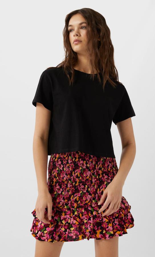 En tono fucsia, esta falda mini con estampado floral está confeccionado en tejido elástico tipo nido de abeja y cuenta con bajo acabado en volantes. Ahora tiene un precio de 12,59 euros.