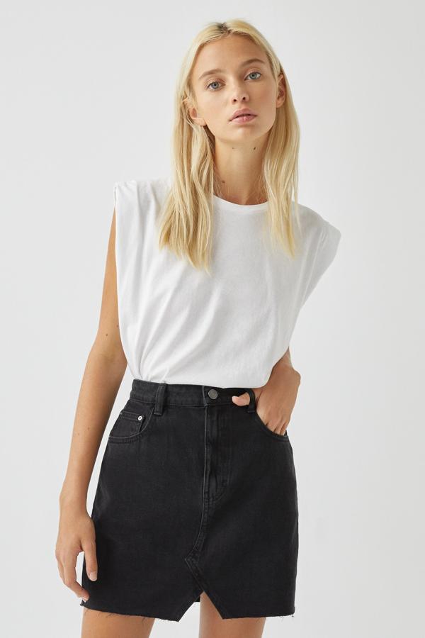 En color negro, esta minifalda denim con detalle de abertura en la parte delantera cuenta con cinco bolsillos, cintura con trabillas y cierre mediante botón y cremallera. Está disponible en más colores y tiene un precio de 17,99 euros.