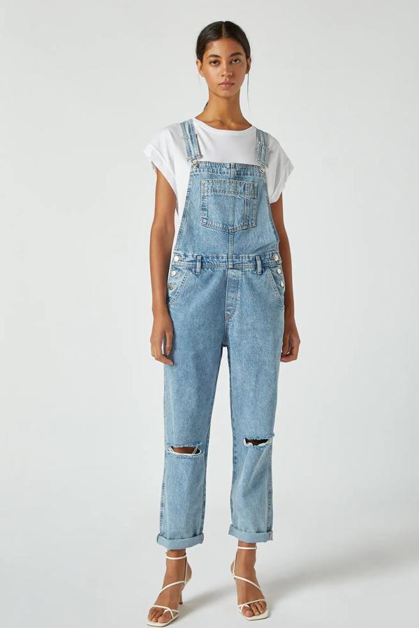 En color azul claro, este peto vaquero largo con detalle de rotos en la rodilla cuenta con tirantes ajustables, bolsillos y cintura con trabillas. Tiene un precio de 29,99 euros.