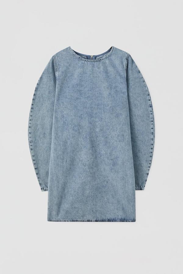 Este vestido mini en tejido vaquero con detalle de volumen en la manga larga cuenta con cuello redondo y está confeccionado en 100% algodón. Tiene un precio de 25,99 euros.