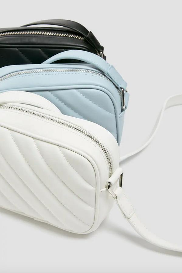En blanco, celeste o negro, esta bandolera acolchada con diseño de rayas anchas diagonales viene con asa de hombro a tono y cierre de cremallera. Es de Pull&Bear y cuesta 12,99 euros.
