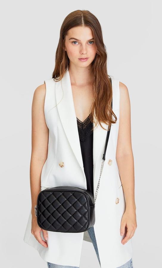 Asa larga en cadena y piel para esta bandolera con cierre de cremallera con abalorios y diseño de rombos. Es de Stradivarius y cuesta 12,99 euros.