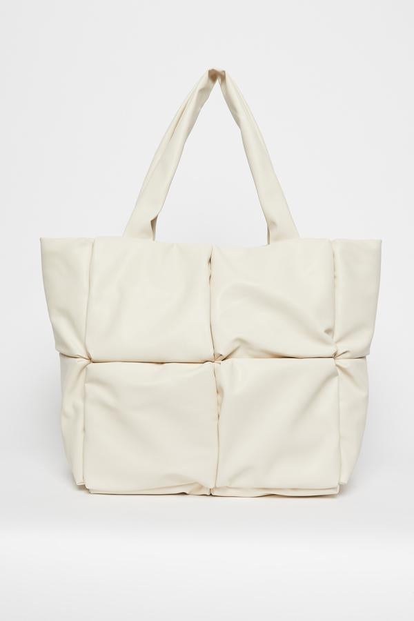 Diseño shopper en color blanco para este bolso acolchado de Sfera con asa de hombro y cierre superior metálico que cuesta 24,99 euros.