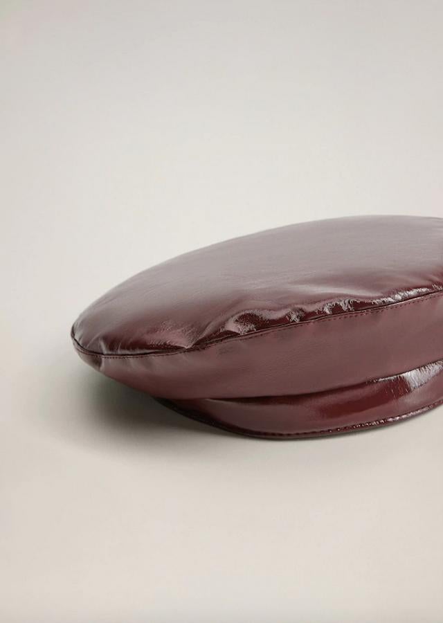 En color burdeos, con efecto charol y forro interior, esta boina de Mango tiene un precio de 15,99 euros.