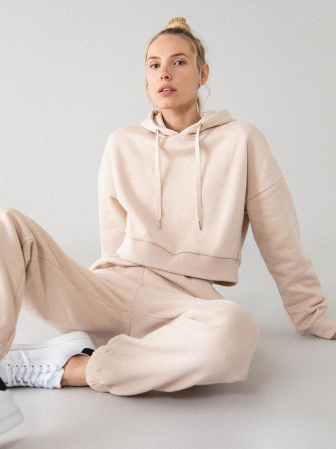 Diseño crop y capucha ajustable con cordones para esta sudadera de chándal que cuesta 8,99 euros y podemos encontrar entre las tallas S y XL en caqui, negro, rosa empolvado y gris.