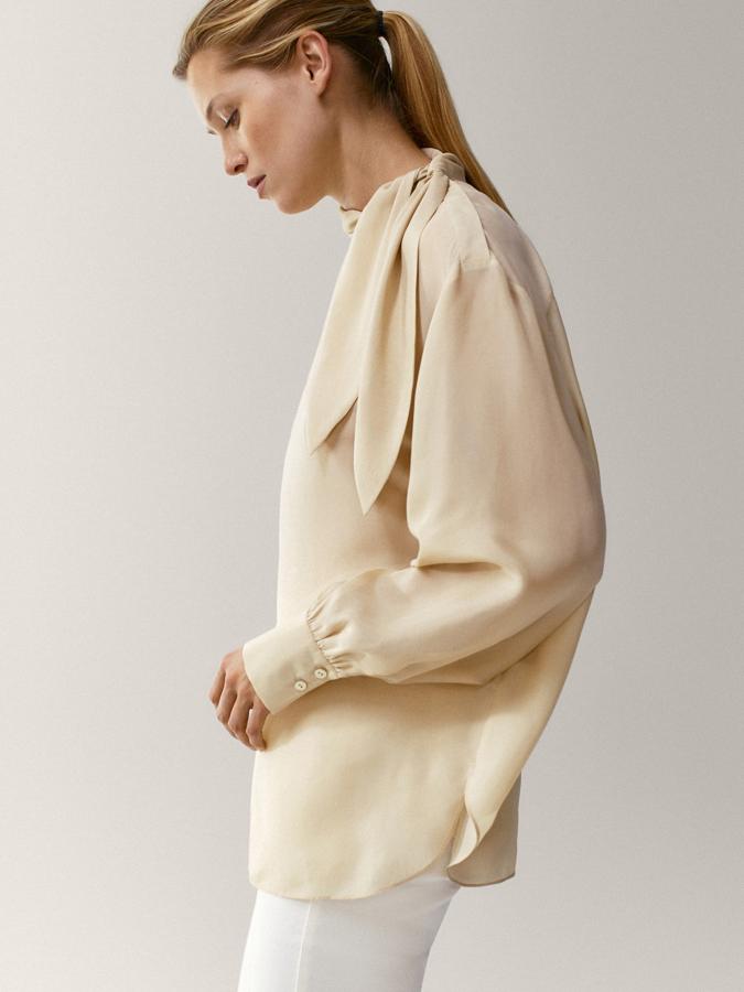 Oversize, perfecta para llevar por fuera con unos vaqueros pitillo o leggings, esta blusa con lazada lateral es de Massimo Dutti (49,95 euros).