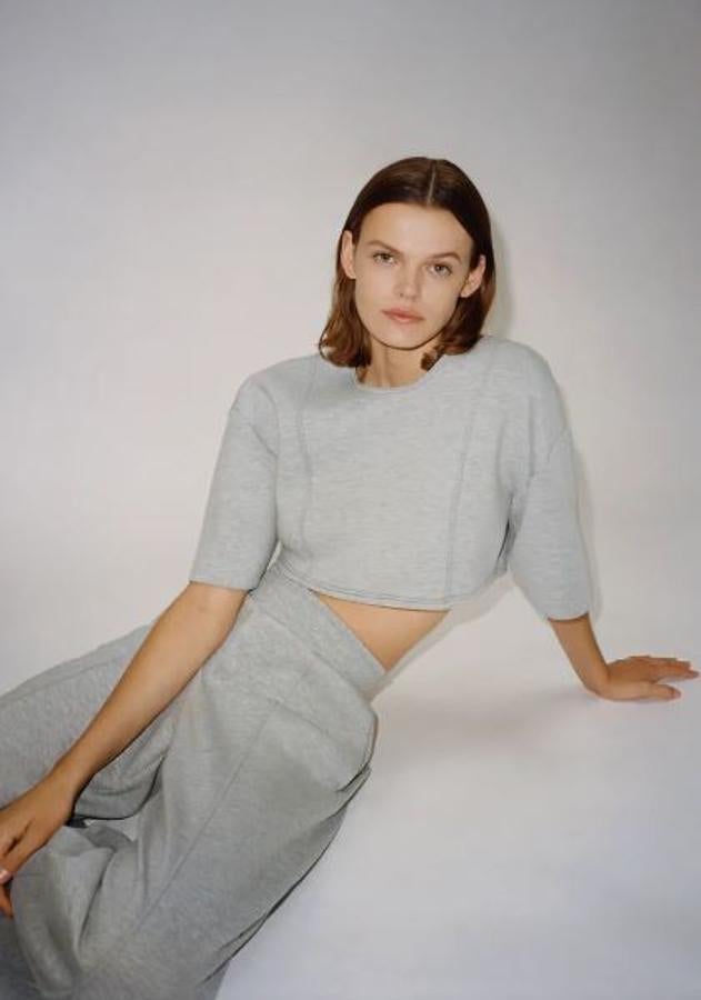 La versión cortita del chándal es gris, en un tejido grueso parecido al neopreno, y se vende en Zara. Puedes comprar el top por 19,95 euros y el pantalón a juego por 25,95.