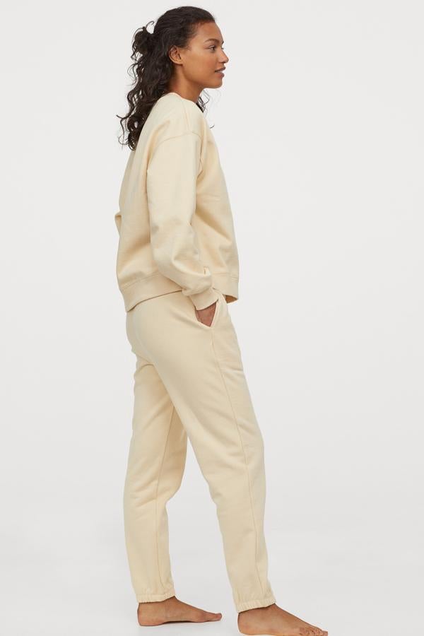 De algodón grueso en tono amarillo pastel, chándal básico de H&M disponible en diferentes colores, todos soft. Cada una de las prendas cuesta 14,99 euros.