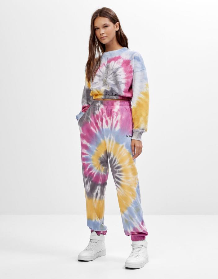 ¿Fan del tie dye? También hay un chándal con el estampado de moda y es este de Bershka. La sudadera cuesta 19,99 y el pantalón, 22,99 euros.