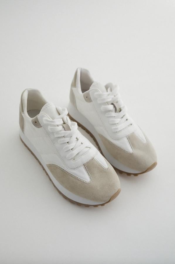 Suela dentada y combinación de materiales en blanco y crudo para estas zapatillas de Zara con cordones blancos. Pertenecen a la colección sostenible de la firma y cuestan 35.95 euros. Podemos encontrarlas entre los 36 y 42 menos en el 40.