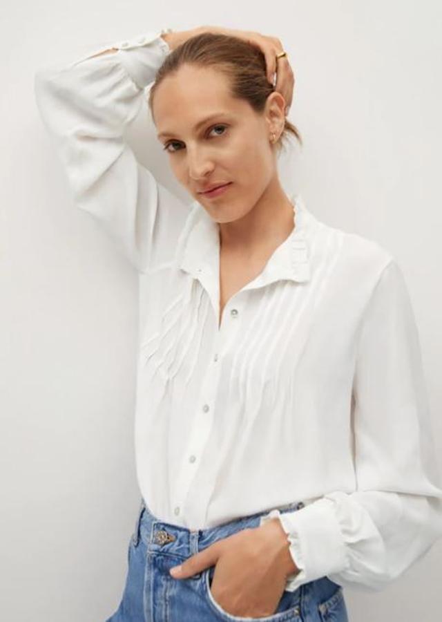 Camisa blanca con pliegues en el pecho y detalle en los puños, de Mango (29,99 euros).