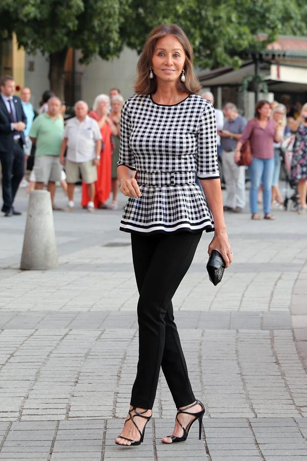 ¿Cómo dar vida a unos pantalones negros? Con un top estampado tan original como este de Isabel Preysler de cuadros vichy en blanco y negro y con volante en el bajo. ¡Ideal!