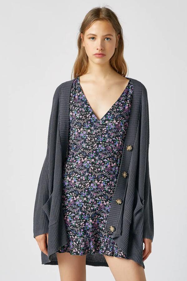 En color plomo (también disponible en crudo), esta chaqueta larga de punto con detalle de botones en contraste cuenta con escote en forma de pico y tiene un precio de 19,99 euros. Es de Pull & Bear.