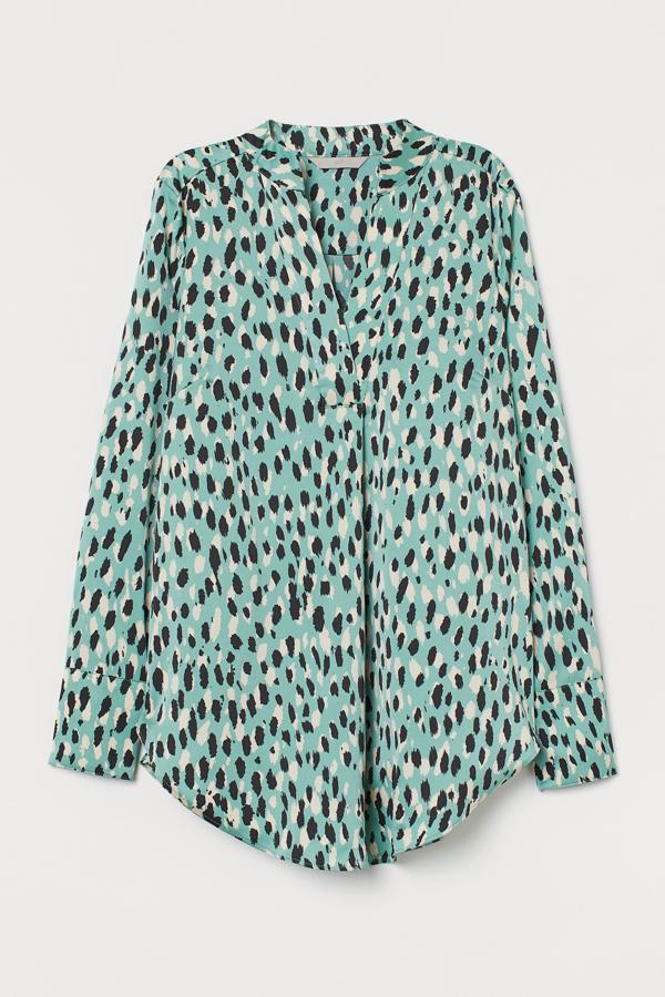 Con estampado de leopardo en color verde, esta blusa de satén con cuello elevado y escote de pico cuenta con pliegue en la parte delantera y bajo redondeado. Está disponible en otros tonos, es de H&M y tiene un precio de 24,99 euros.