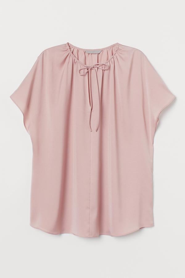 Disponible en color rosa claro o negro, esta blusa de satén de manga corta cuenta con caída suave, abertura de pico con tiras y fruncido decorativo en el escote. Es de H&M y tiene un precio de 14,99 euros.