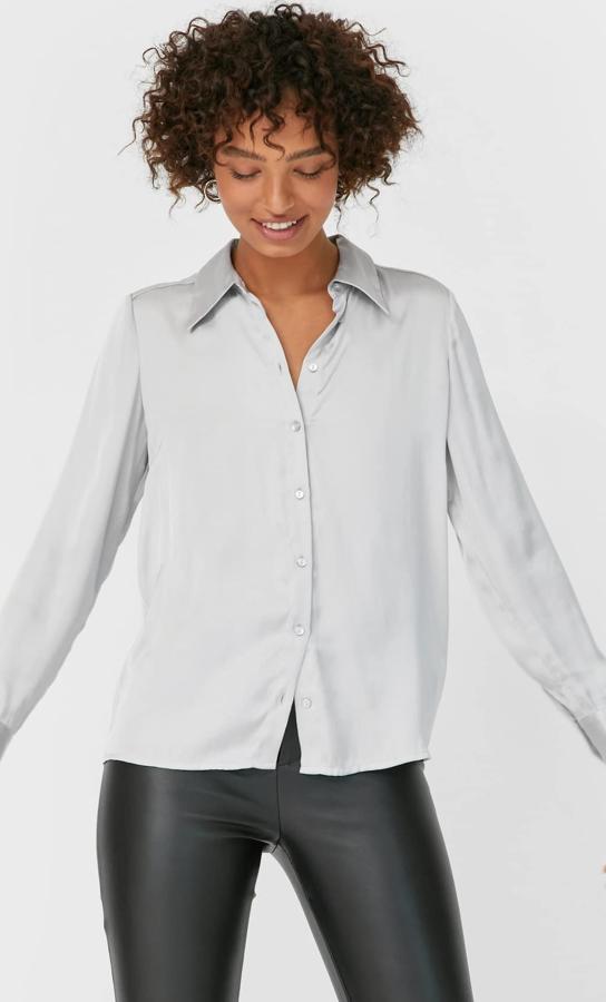 Esta camisa fluida de satén en color gris perla con cuello solapa y manga acabada en puño es de Stradivarius y tiene un precio de 17,99 euros.