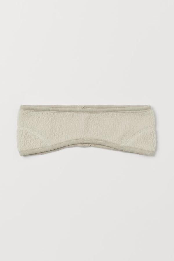 En borreguito suave, confeccionada en poliéster reciclado, esta cinta de pelo en color beige tiene un precio de 7,99 euros.