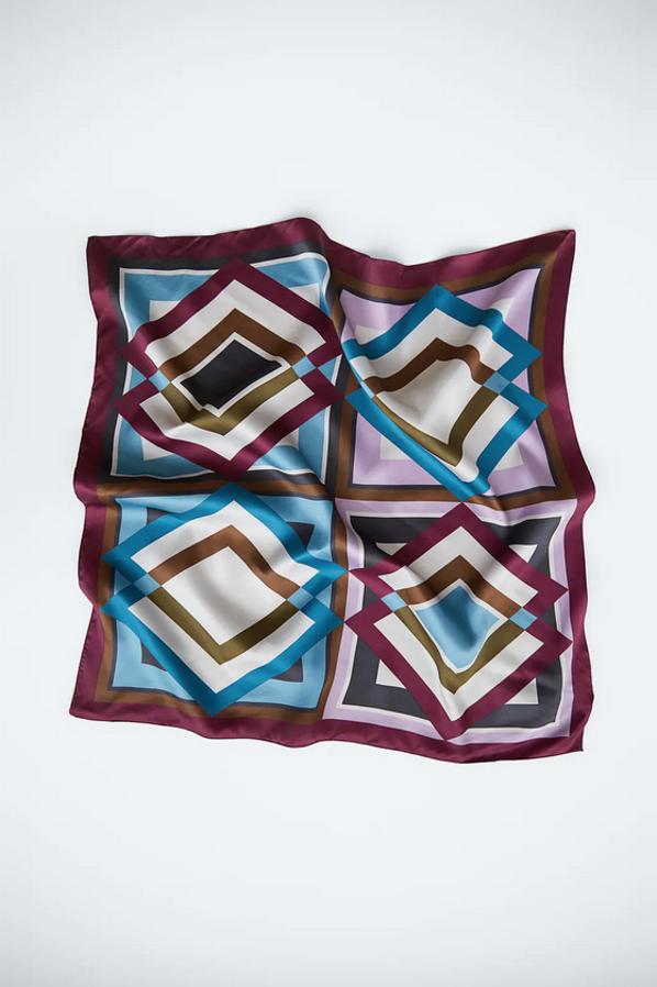 Estampado geométrico en tonos azules, lilas y berenjena para este pañuelo corbatero de Zara que cuesta 9,95 euros.