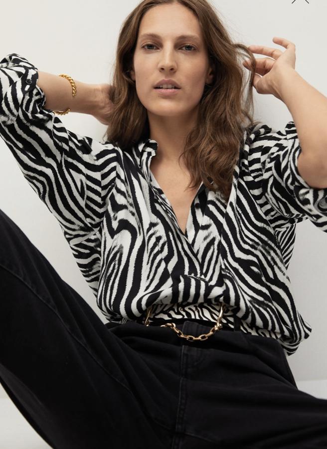 Blusa con mangas con volumen y escote en pico, con estampado de cebra en blanco y negro, de Mango (39,99 euros).