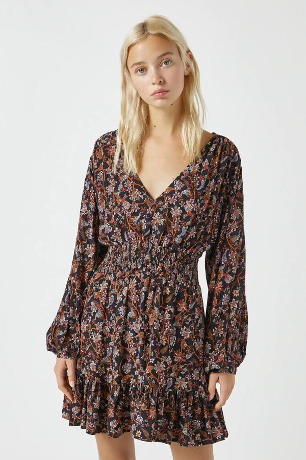 En color negro y con estampado floral, este vestido con detalle de goma doble en la cintura y manga larga cuenta con cuello redondo y tiene un precio de 25,99 euros.