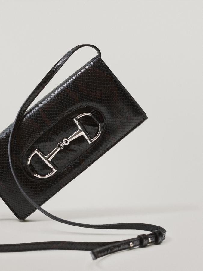 Confeccionado en piel caprina y bovina, este bolso clutch de Massimo Dutti tiene acabado de piel de serpiente y viene con correa de hombro ajustable y detalle de estribo en el frontal. Cuesta 89,95 euros.
