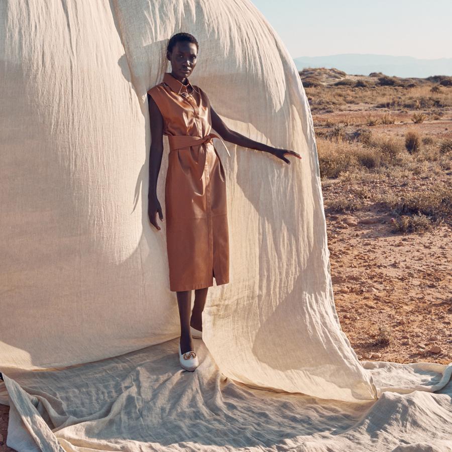 Este vestido camisero de piel en color cámel con detalle de cinturón cuesta 259 euros en Uterqüe.