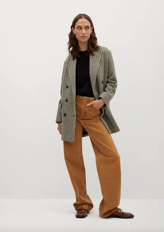 Estampado pata de gallo para este abrigo de lana cruzado de Mango en tonos beige, marrones y negros de diseño medio y tejido con lana. Con cuello de solapa y manga larga con puños abotonados, tiene bolsillos laterales con solapa y cuesta 79,99 euros. Podemos encontrarlo entre las tallas XS y XL.