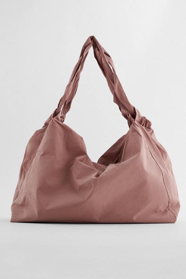 En color rosa, este bolso formato shopper con asas de hombro entrelazadas cuenta con cierre de cremallera y bolsillos interior. Es de Zara y tiene un precio de 25,95 euros.
