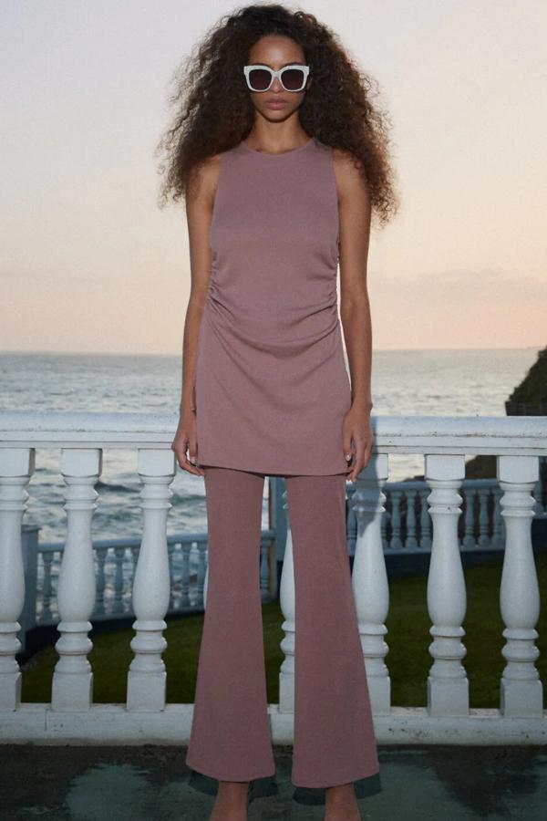 Disponible en morado, negro o tostado, este conjunto está formado por camiseta (17,95 euros) larga con manga sisa y detalle drapeado lateral y pantalón (17,95 euros) de tiro alto con cintura elástica.